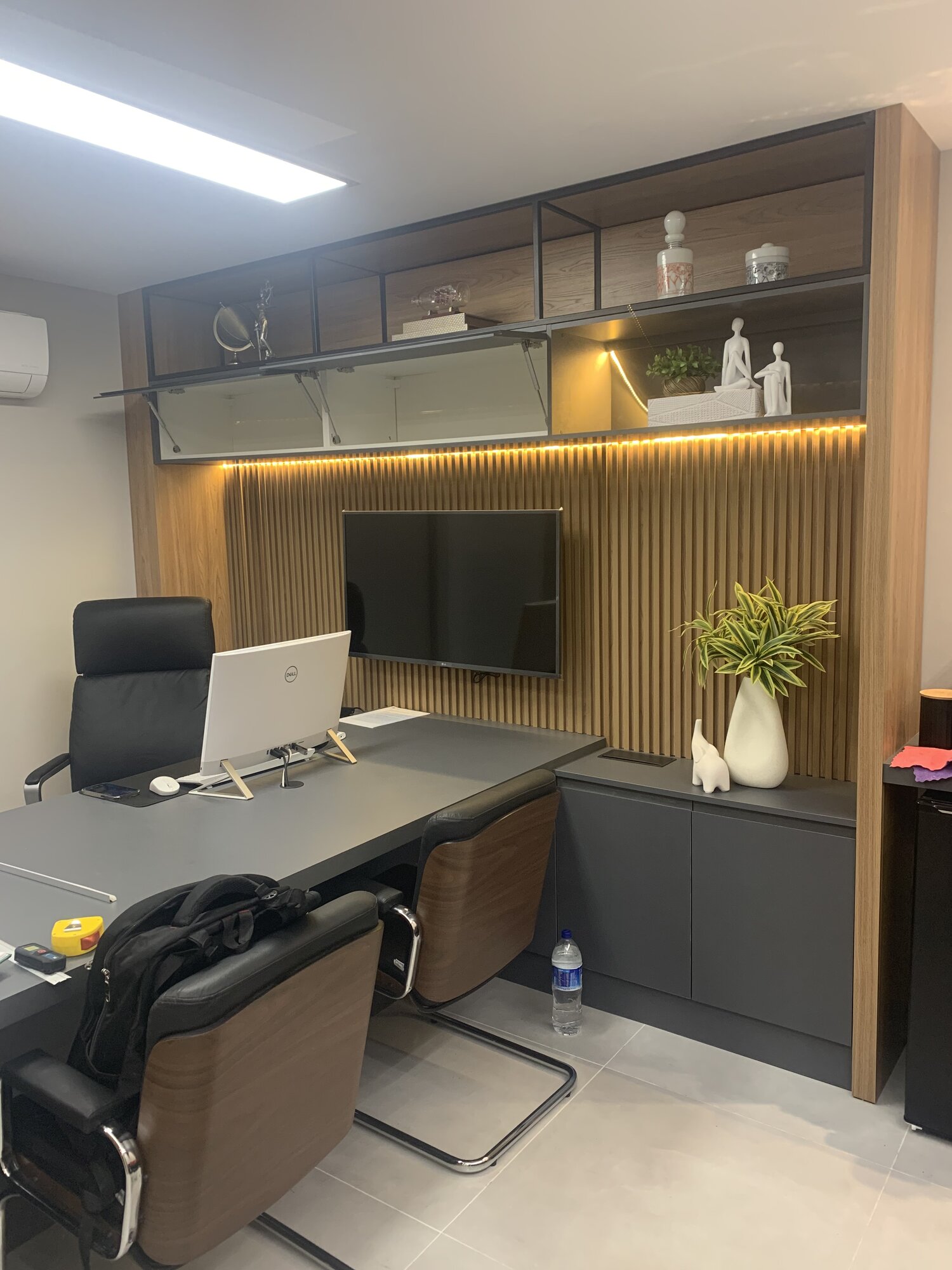Escritório planejado com mesa, painel ripado e nichos em vidro